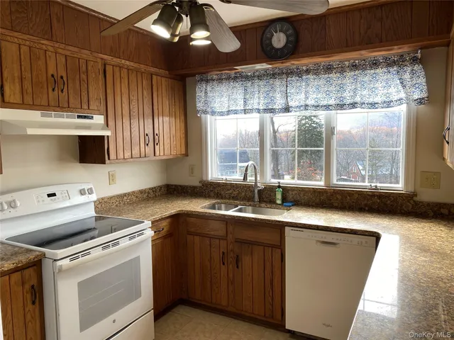 a kitchen with a sink window and cabinets
