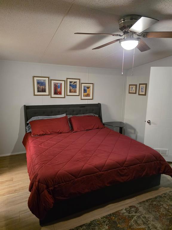 115 Yates Circle Aledo, TX 76008 - Photo 29 of 31 a bedroom with a large bed and a chandelier