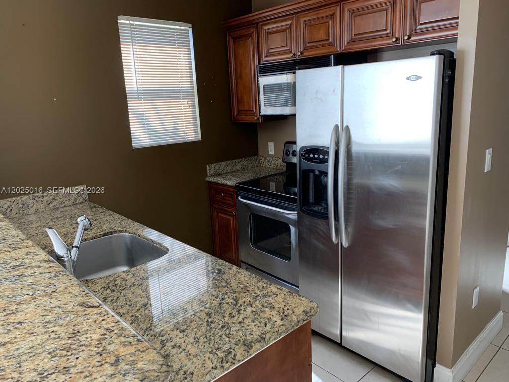 400 Southwest 2nd Street, Unit 201 Miami, FL 33130 - Photo 4 of 12 a kitchen with a refrigerator and a sink