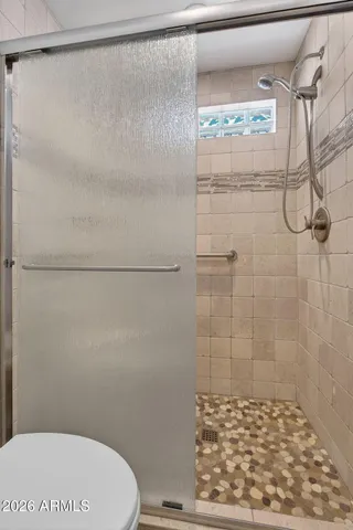 a bathroom with a granite countertop sink a mirror and a shower