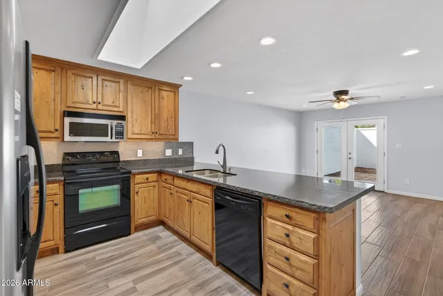 a kitchen with stainless steel appliances granite countertop a refrigerator a stove top oven a sink and dishwasher