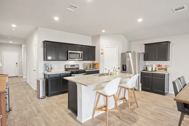 a view of a dining room with furniture a rug and wooden floor