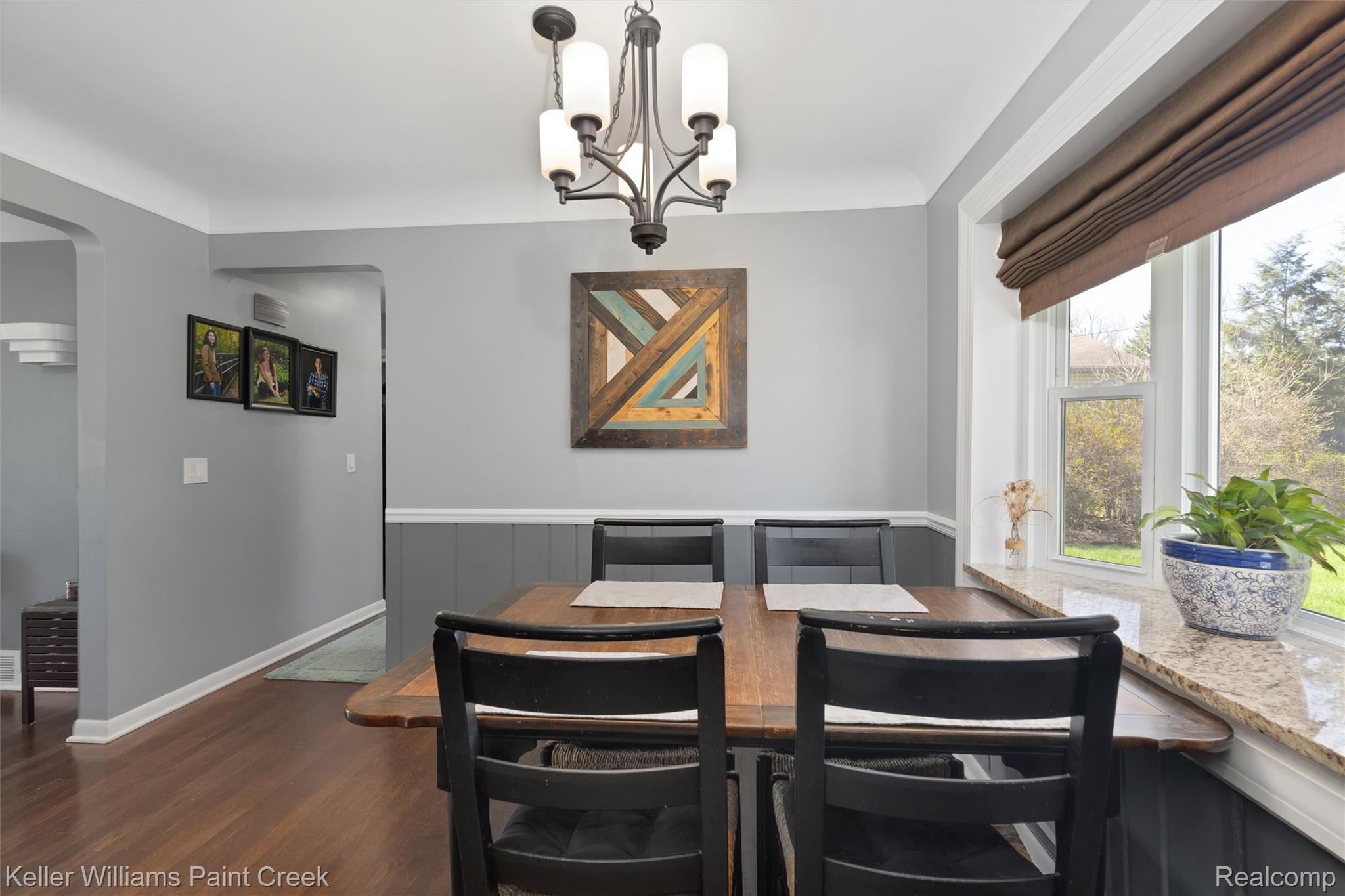 310 Elmhill Road Rochester, MI 48306 - Photo 10 of 37 Dining space with dark wood-style flooring, arched walkways, hanging lights, and wainscoting