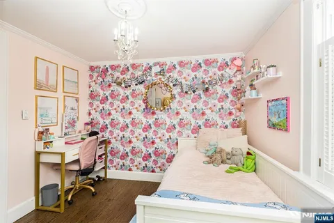 a view of a bedroom with paintings on the wall and a window