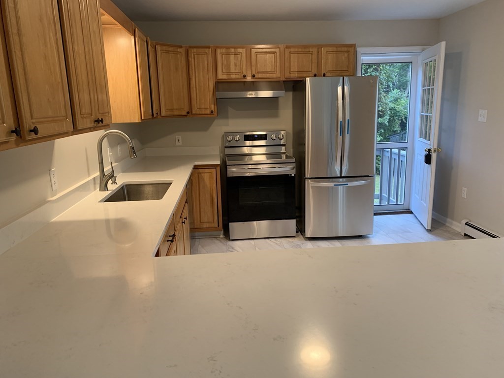 581 Warren Wright Road Belchertown, MA 01007 - Photo 11 of 25 a kitchen with refrigerator a stove a washer and dryer
