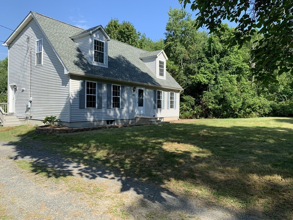 581 Warren Wright Road Belchertown, MA 01007 - Photo 4 of 25 a front view of house with yard and green space