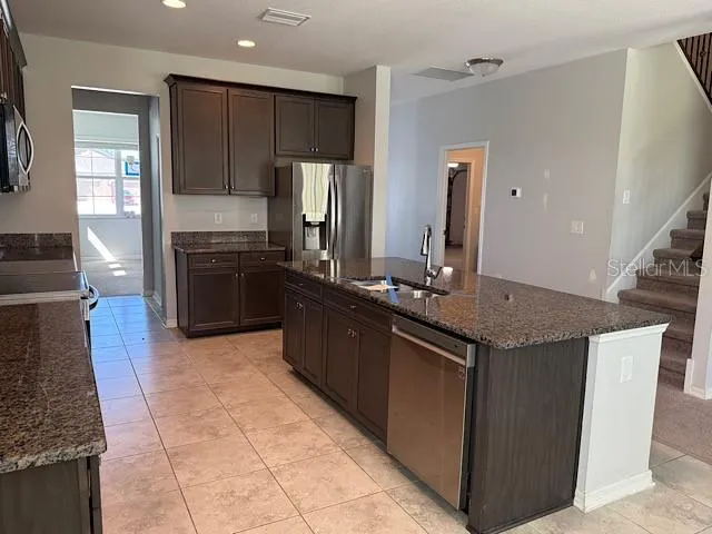 a kitchen with stainless steel appliances granite countertop a stove a refrigerator and a oven