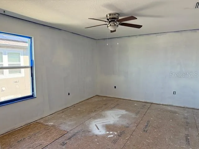 a view of room with a ceiling fan and a window