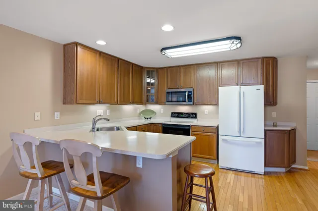 a kitchen with a refrigerator a stove and a dining table