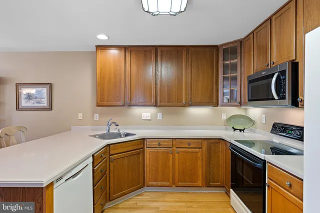 a kitchen with stainless steel appliances granite countertop a sink a stove a microwave oven with cabinets and wooden floor