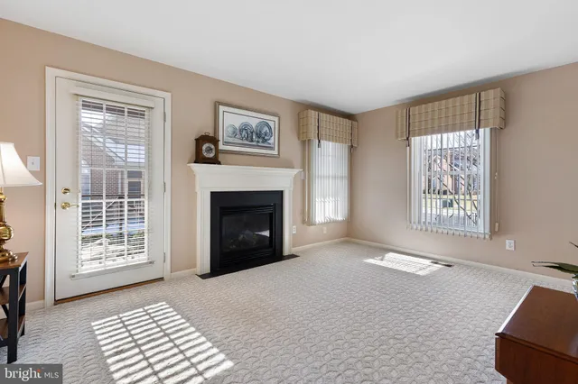 a view of an empty room with a window and fireplace