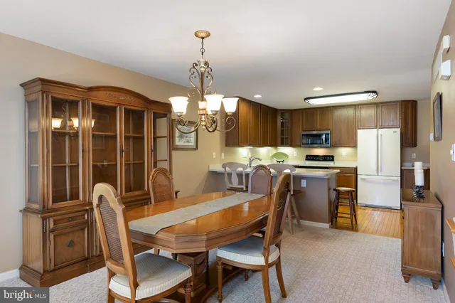 a view of a dining room with furniture a chandelier and wooden floor
