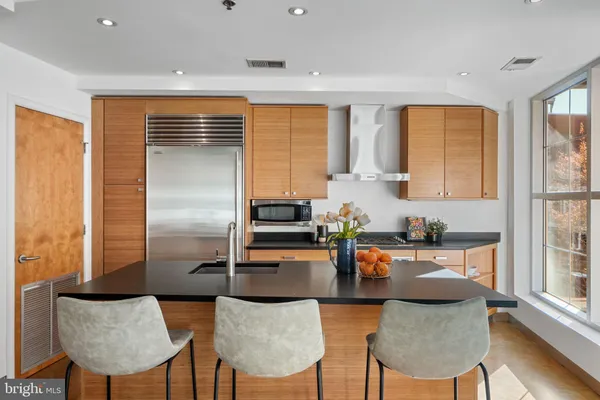 a kitchen with stainless steel appliances granite countertop a refrigerator and cabinets