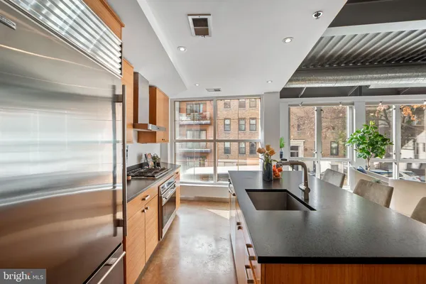 a kitchen with a refrigerator a sink and dining table