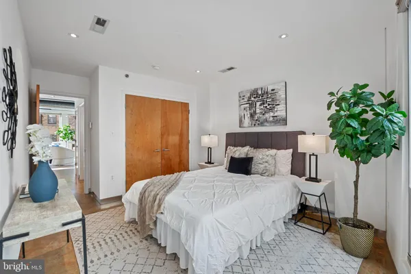a bedroom with a bed and wooden floor
