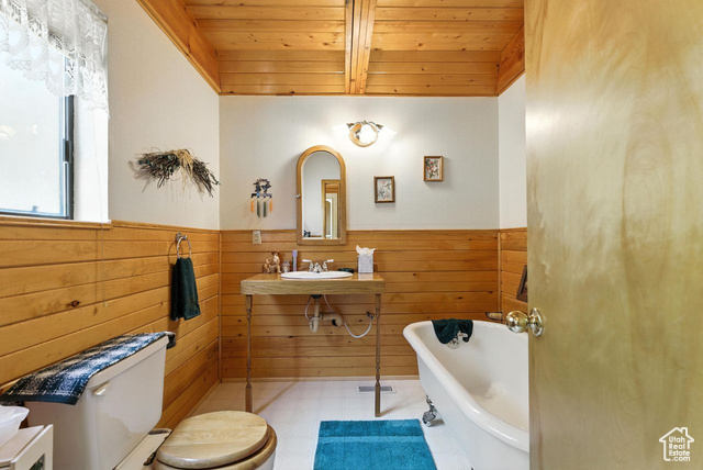 1180 Oak Road Coalville, UT 84017 - Photo 9 of 25 Full bathroom featuring a freestanding tub, tile patterned floors, wooden ceiling, wooden walls, and a wainscoted wall