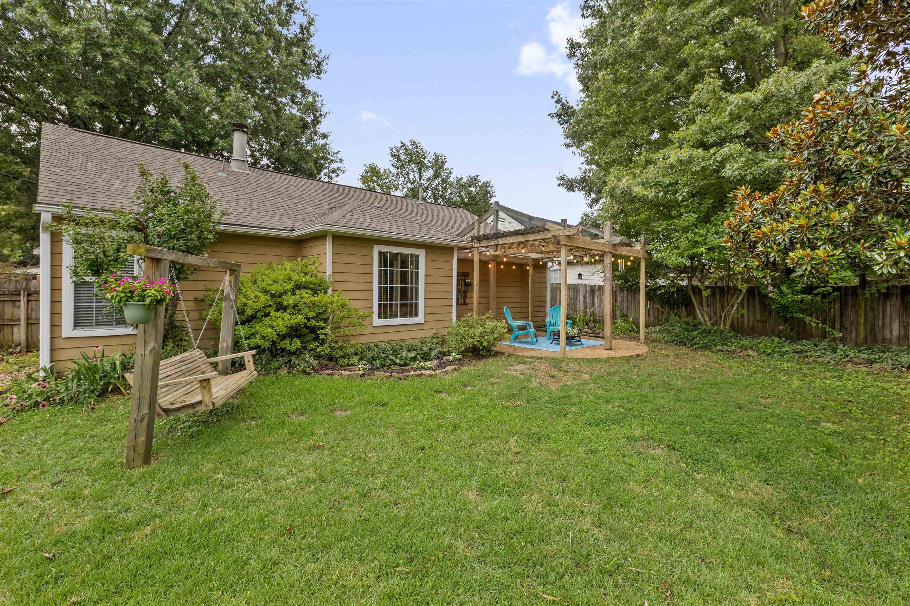1379 Lagrange Downs Road Cordova, TN 38018 - Photo 32 of 35 Expansive backyard featuring a lush lawn, mature trees, and a wooden pergola with a circular paved patio