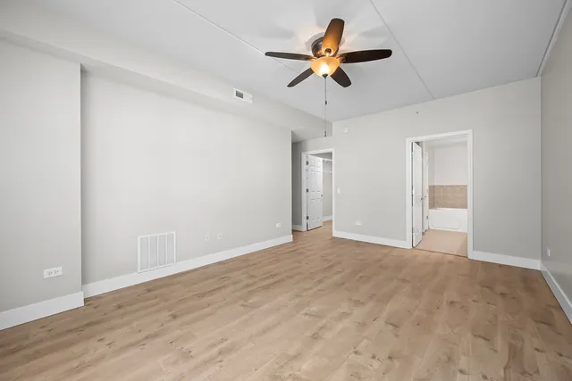 a view of room with ceiling fan and wooden floor