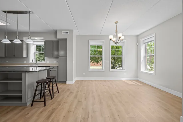 a kitchen with kitchen island granite countertop a stove a sink and a wooden floors