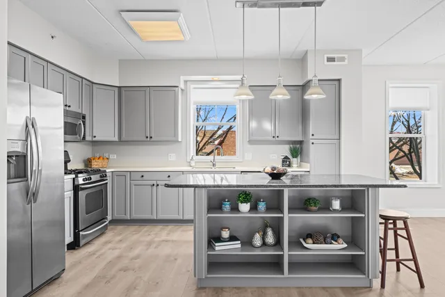 a kitchen with white cabinets and stainless steel appliances