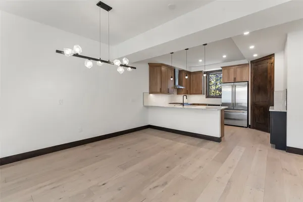 a view of kitchen with stainless steel appliances refrigerator oven and cabinets