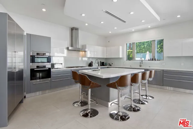 a kitchen with stainless steel appliances kitchen island granite countertop a sink and cabinets