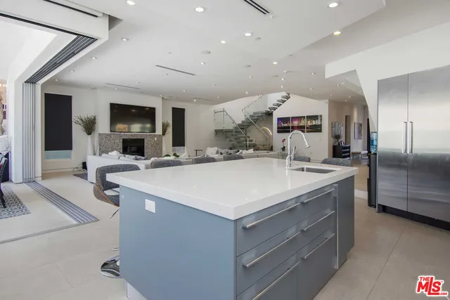 a large kitchen with a sink and a large refrigerator