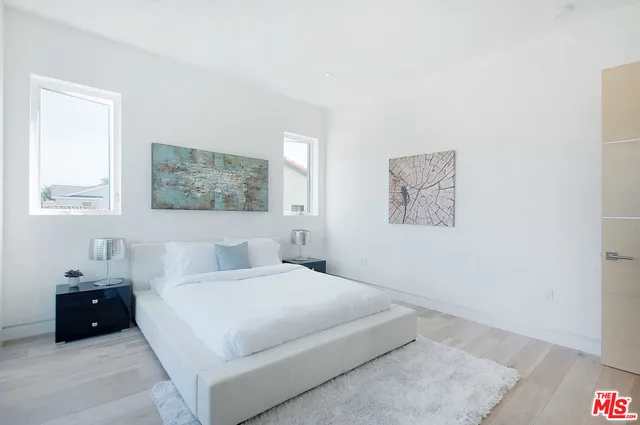 a bedroom with a bed and a painting on the wall