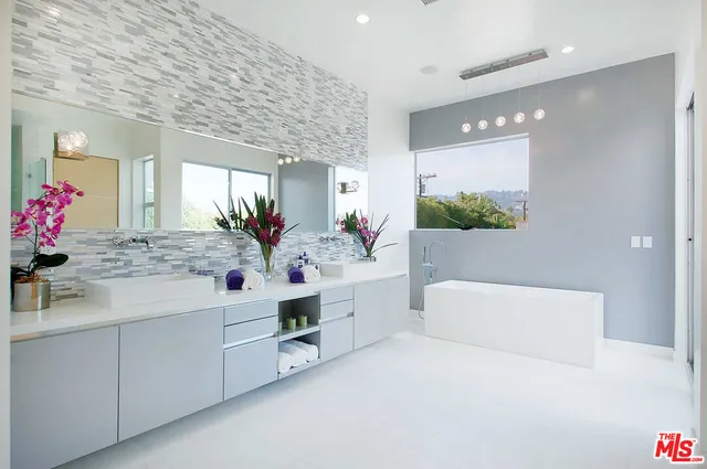 a bathroom with a double vanity sink mirror and bathtub