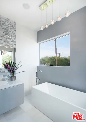 a bathroom with a bathtub a sink and a window