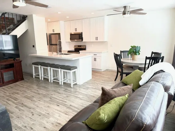 a living room with furniture a flat screen tv and kitchen view