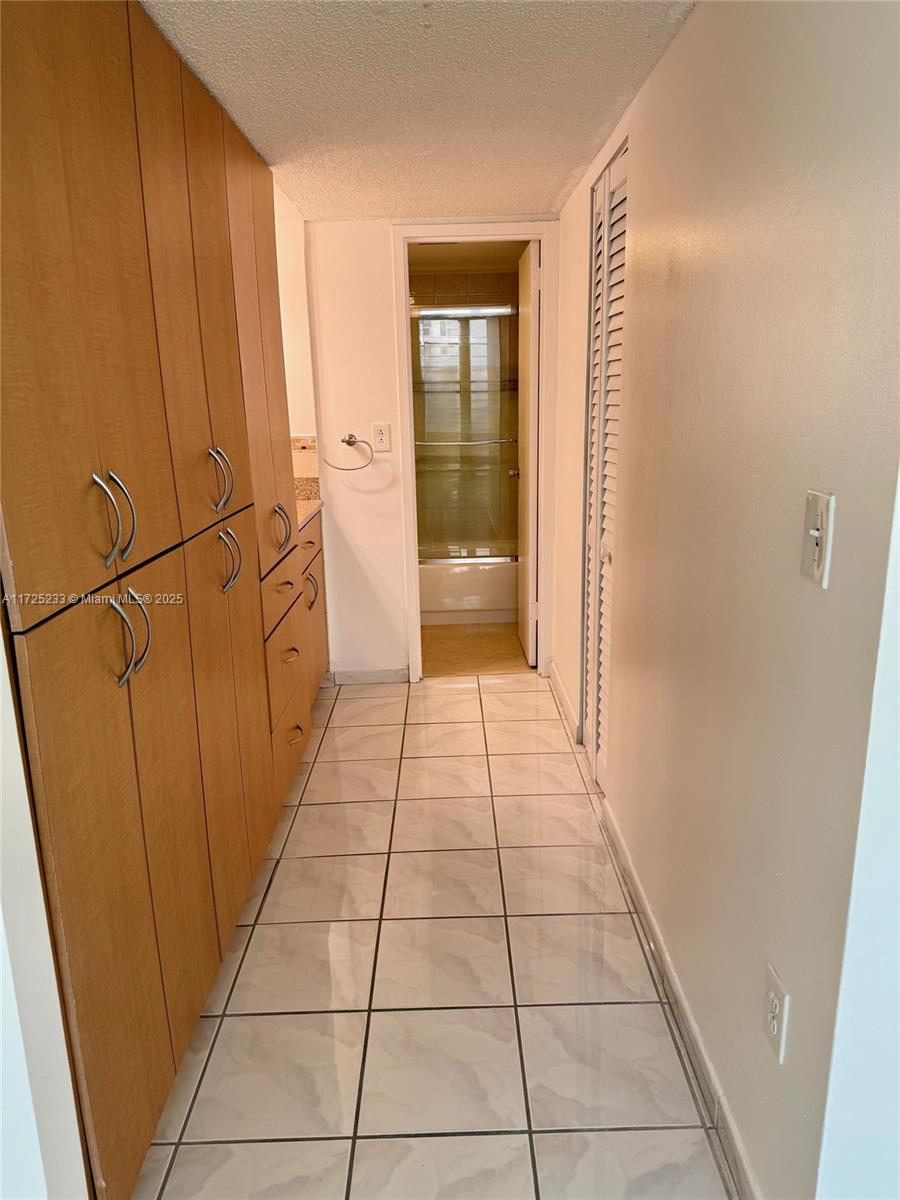 5701 Collins Avenue, Unit 1011 Miami Beach, FL 33140 - Photo 16 of 46 a hallway with view of a bathroom