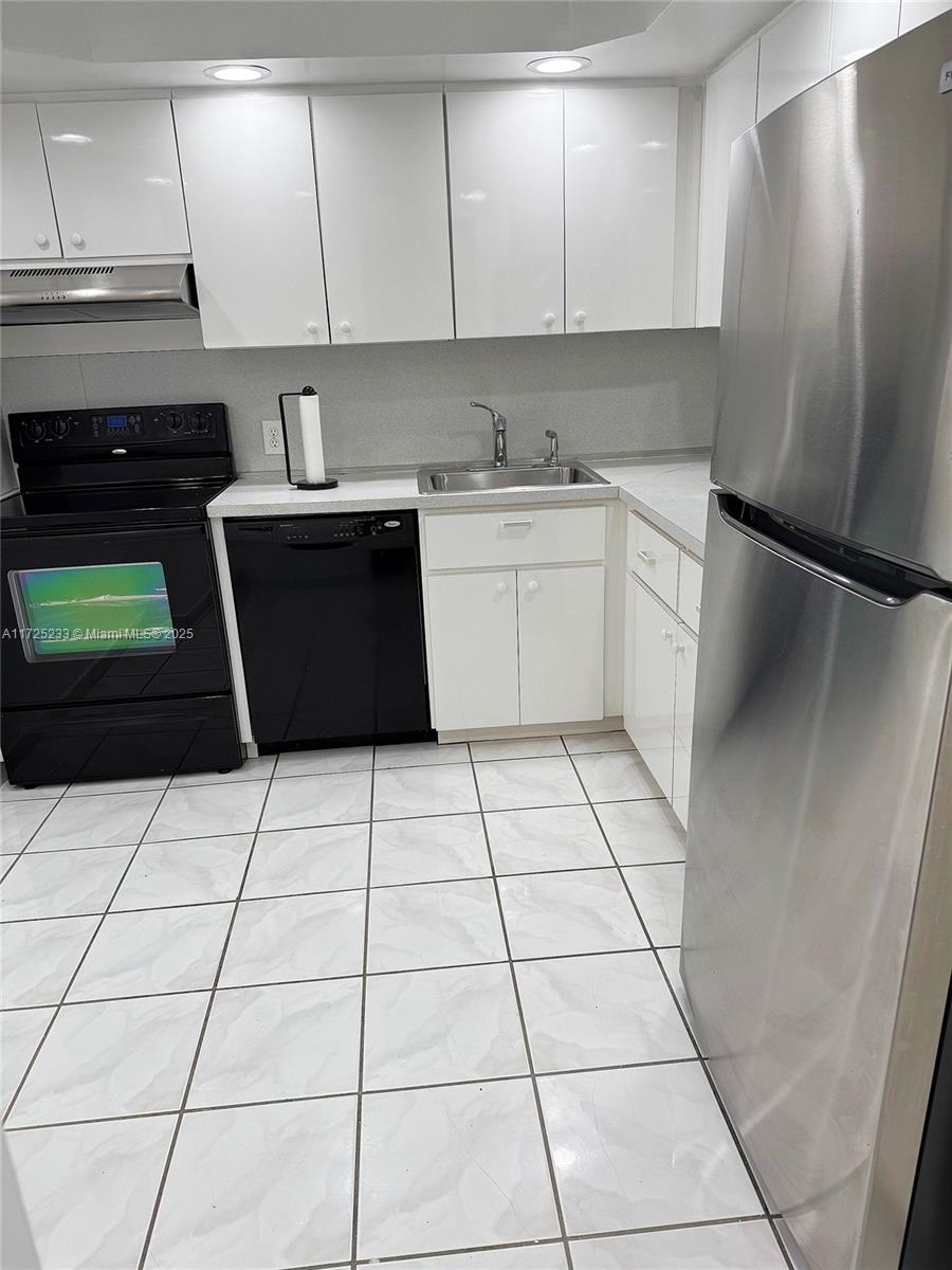 5701 Collins Avenue, Unit 1011 Miami Beach, FL 33140 - Photo 7 of 46 a kitchen with a sink a stove and cabinets