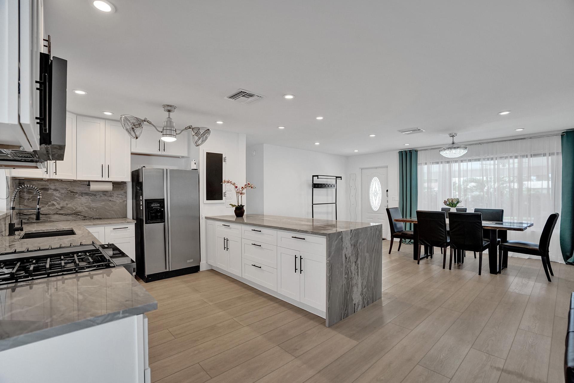2425 Southeast 6th Street Pompano Beach, FL 33062 - Photo 8 of 18 a kitchen with stainless steel appliances kitchen island granite countertop a stove and a refrigerator