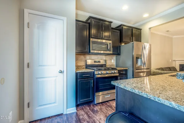 a kitchen with stainless steel appliances granite countertop a refrigerator and a stove