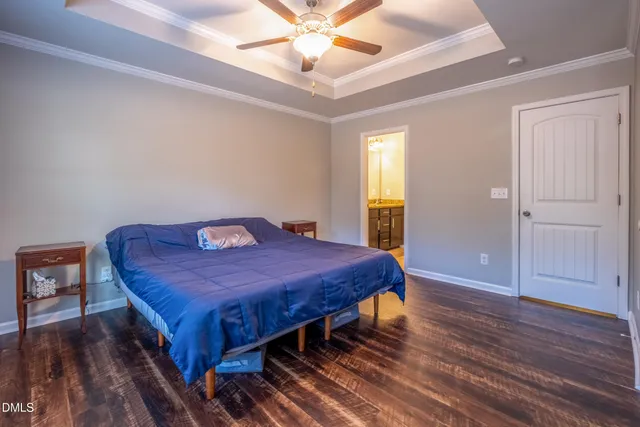 a spacious bedroom with a bed and wooden floor