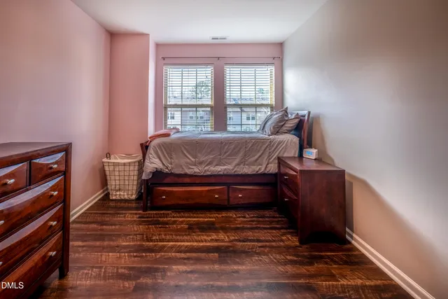a bedroom with a bed and wooden floor