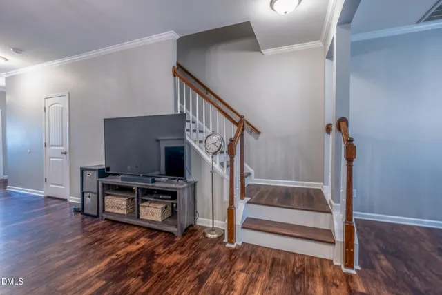 a view of a livingroom with wooden floor and staircase