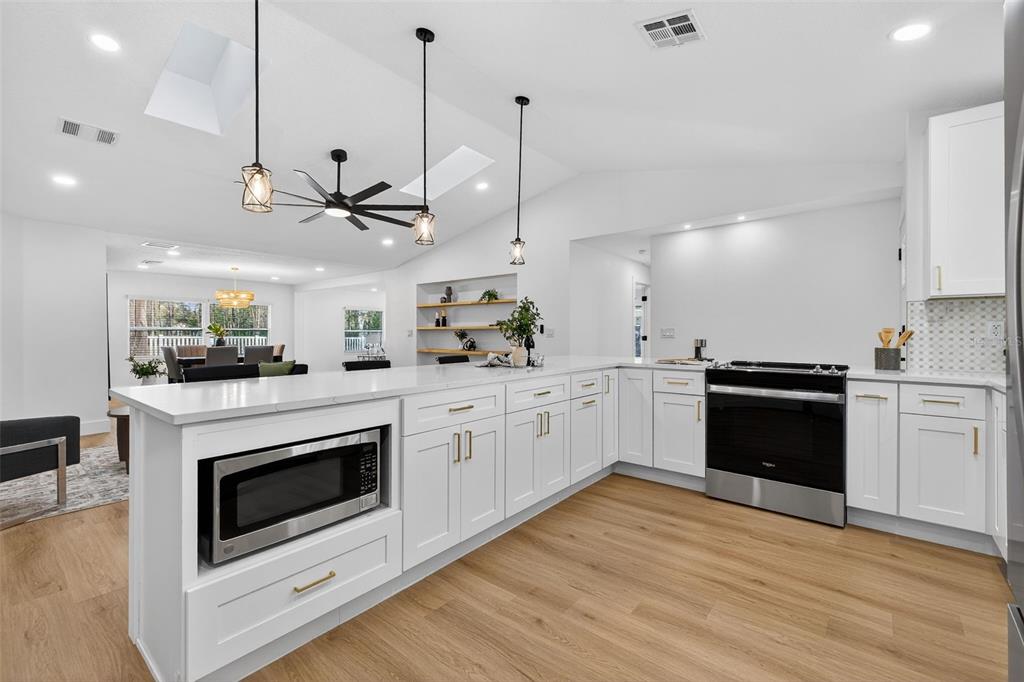 1120 Country Lane Lutz, FL 33558 - Photo 11 of 52 a kitchen with stainless steel appliances granite countertop a stove a sink and a wooden floors