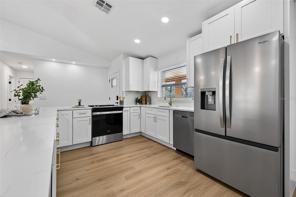 1120 Country Lane Lutz, FL 33558 - Photo 12 of 52 a kitchen with a refrigerator and a white cabinets