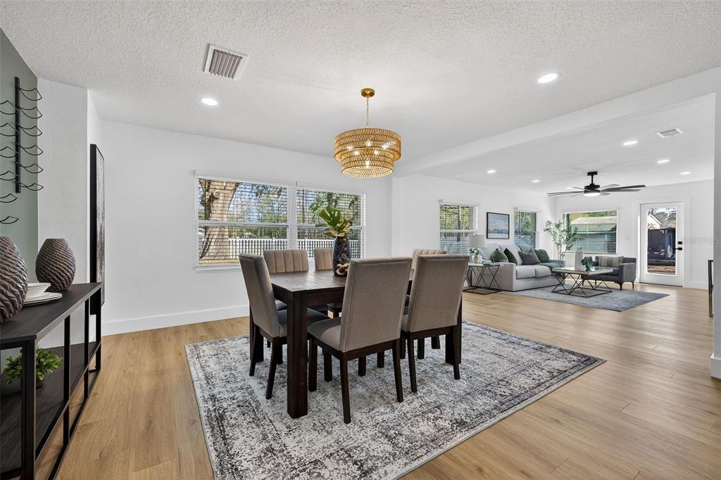 1120 Country Lane Lutz, FL 33558 - Photo 22 of 52 a dining room with furniture a rug a potted plant and wooden floor
