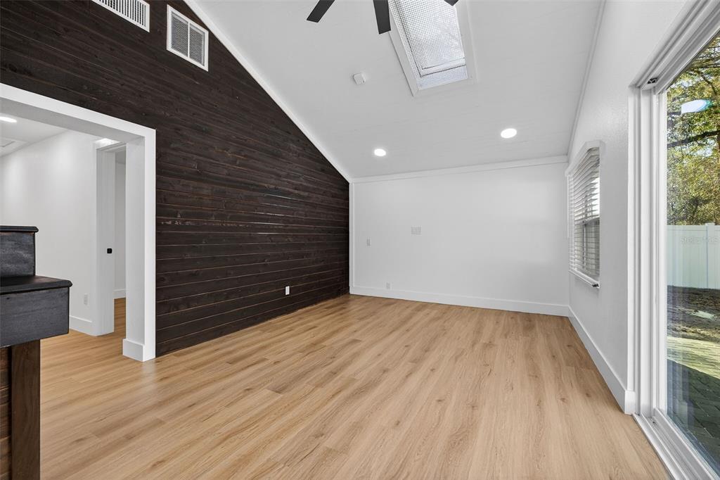 1120 Country Lane Lutz, FL 33558 - Photo 32 of 52 a view of an empty room with wooden floor and a window