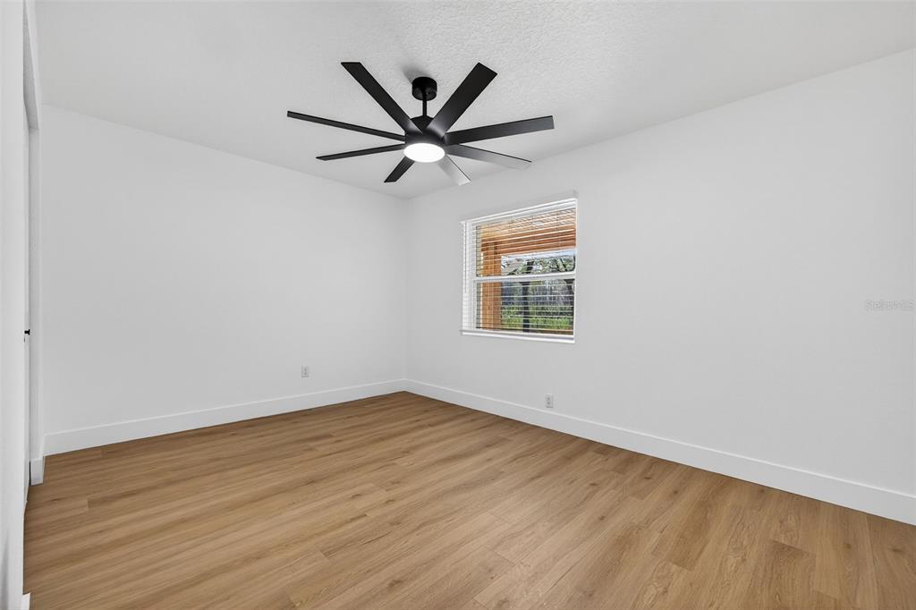 1120 Country Lane Lutz, FL 33558 - Photo 33 of 52 an empty room with wooden floor a ceiling fan and window