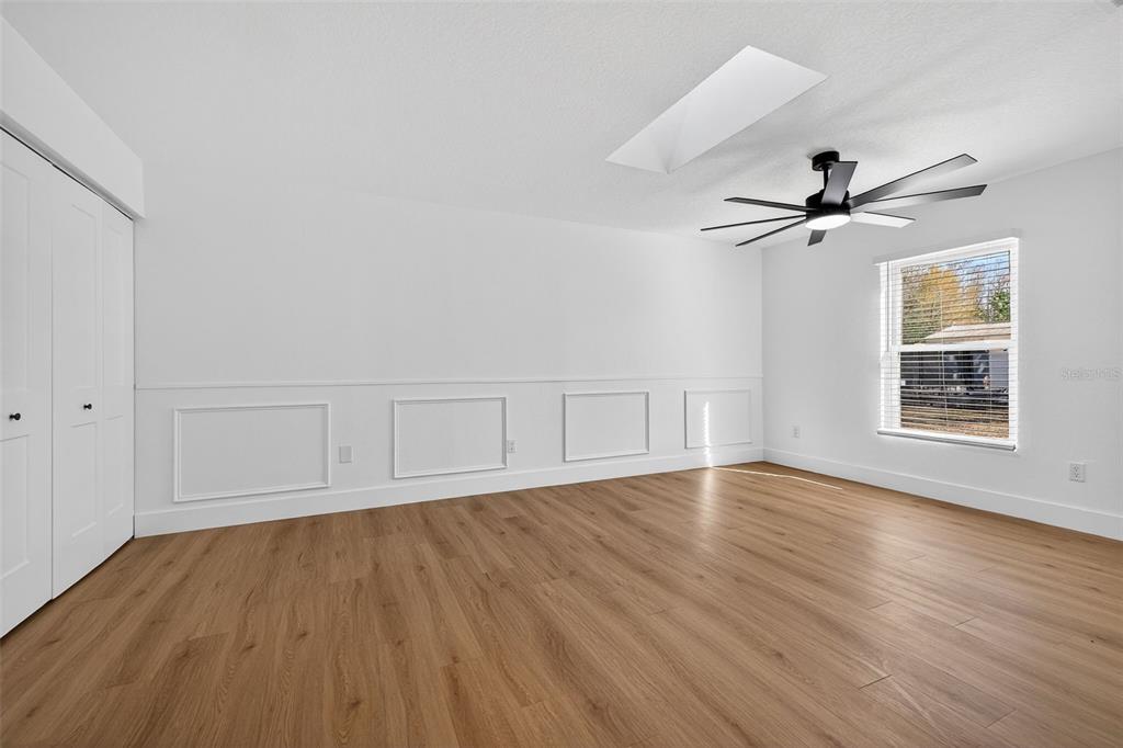1120 Country Lane Lutz, FL 33558 - Photo 34 of 52 an empty room with wooden floor chandelier fan and windows