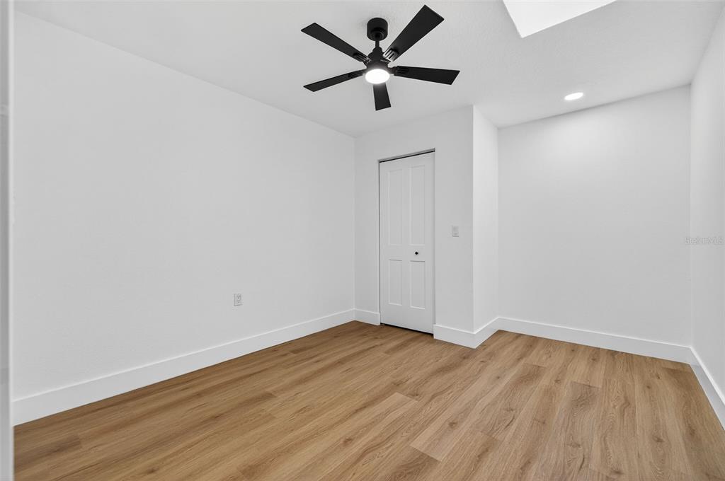 1120 Country Lane Lutz, FL 33558 - Photo 37 of 52 an empty room with wooden floor and a ceiling fan