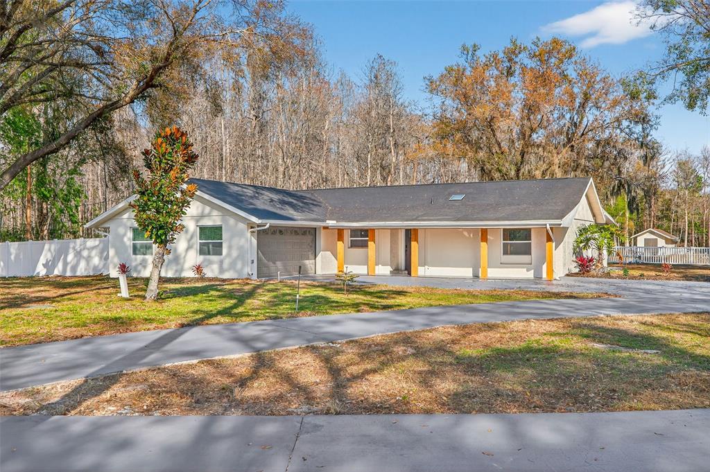 1120 Country Lane Lutz, FL 33558 - Photo 7 of 52 a view of a house with a big yard and large trees