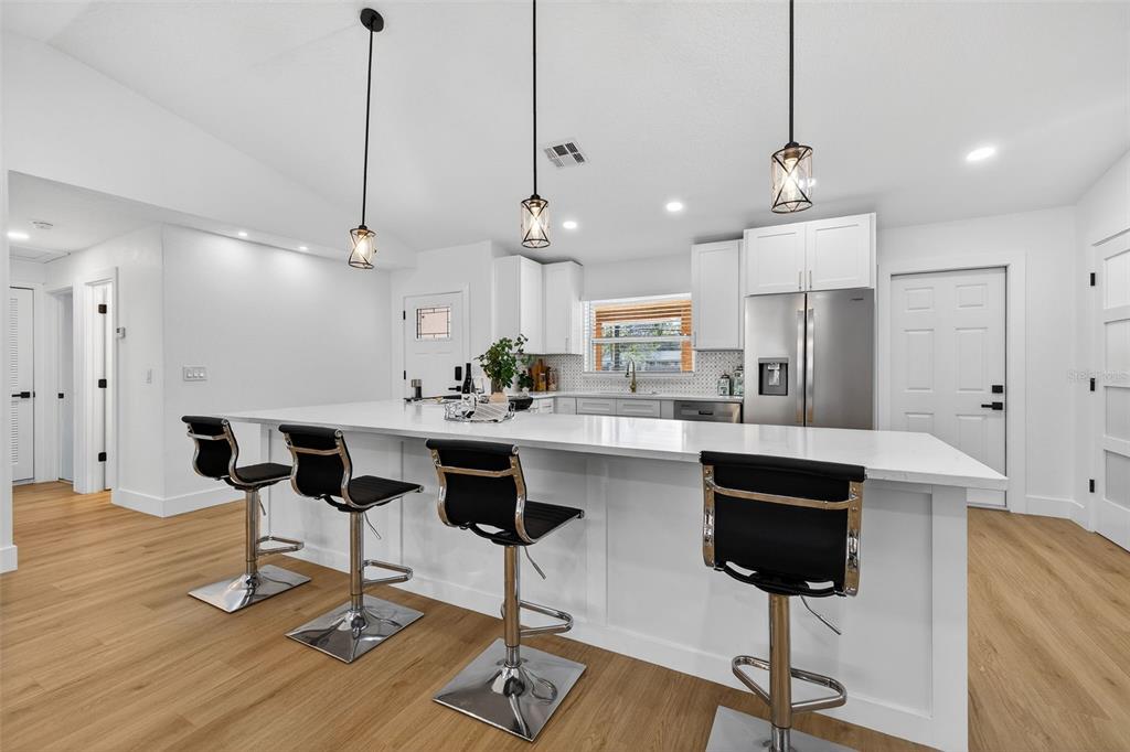 1120 Country Lane Lutz, FL 33558 - Photo 9 of 52 a kitchen with stainless steel appliances kitchen island a table chairs and a chandelier