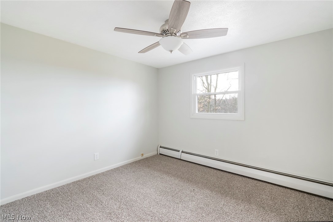 25005 West Egypt Road Minerva, OH 44657 - Photo 32 of 33 Empty room with light carpet, ceiling fan, and baseboard heating