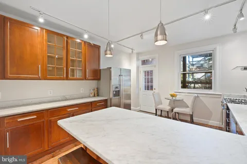 a bedroom with a large bed a chandelier and windows