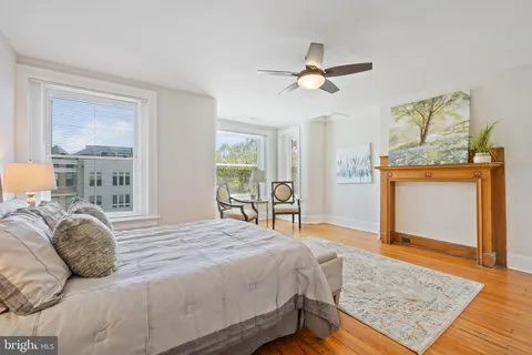 a bedroom with a bed and a dresser with mirror